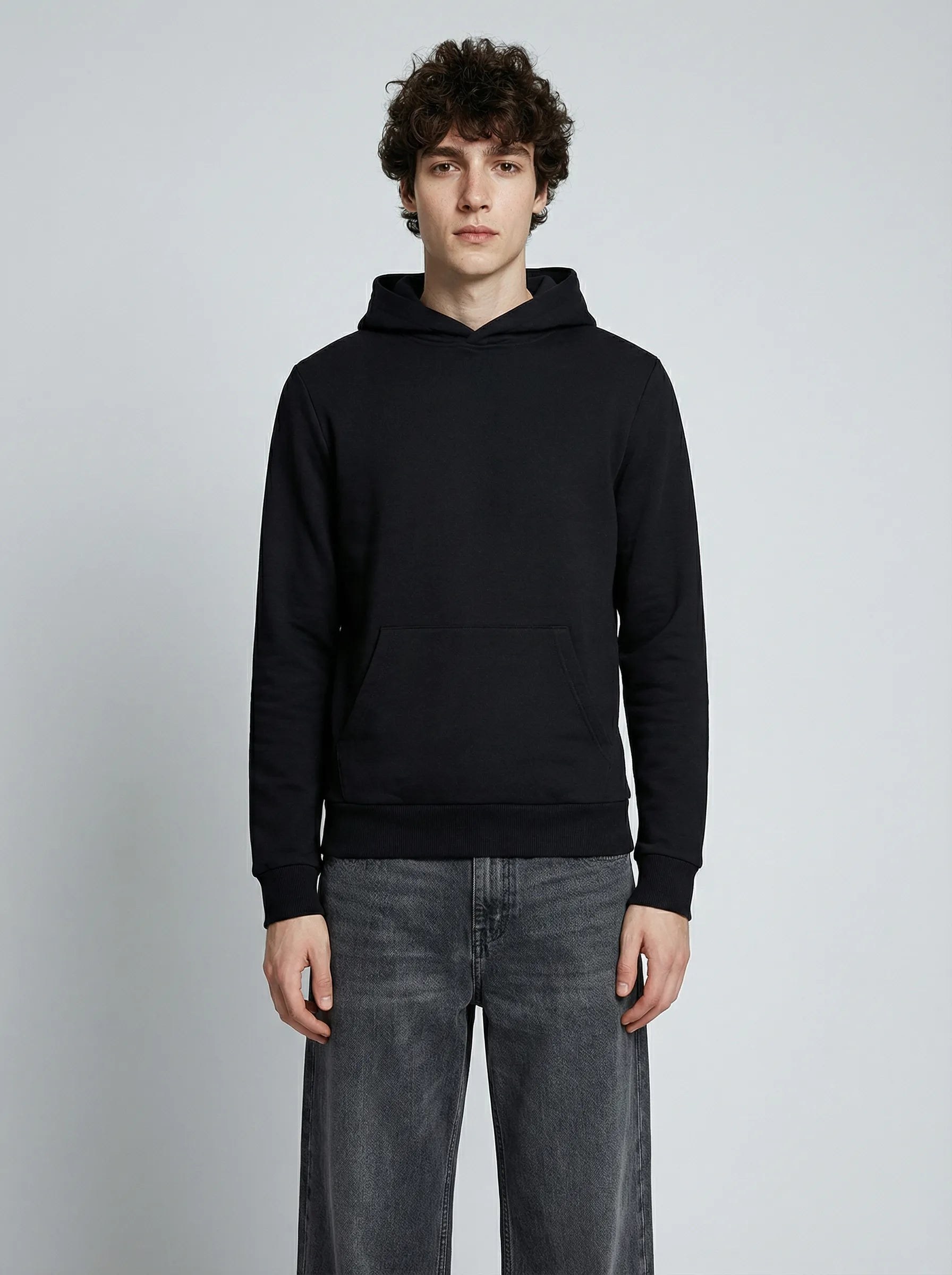 Homme portant un hoodie noir en coton biologique, posture droite de face